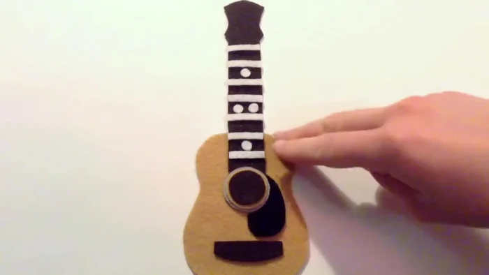 Glue the seven white strips and four small white circles onto the dark brown piece.