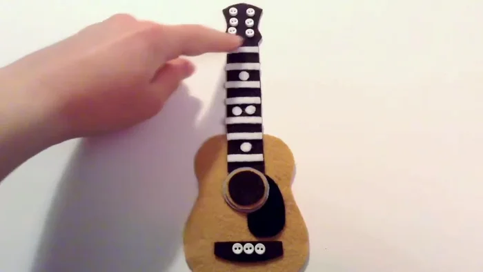 Stitch the strings using white thread, going through the buttons as demonstrated in the video. Ensure stitches are loose enough to lay flat and not bunch.