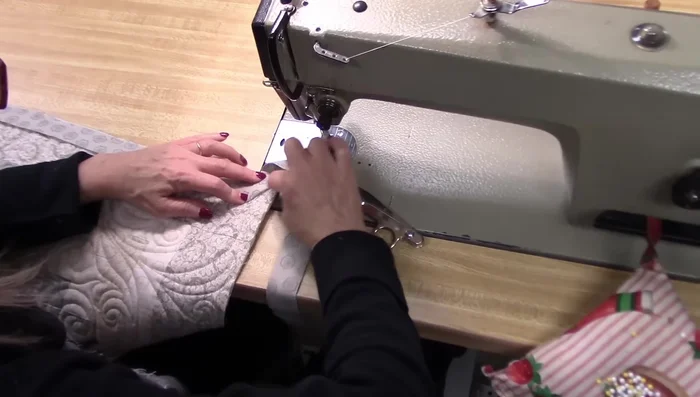 Fold the binding at a 45° angle, aligning raw edges. Finger press and fold down, ensuring the fold and raw edge are on the same line. 