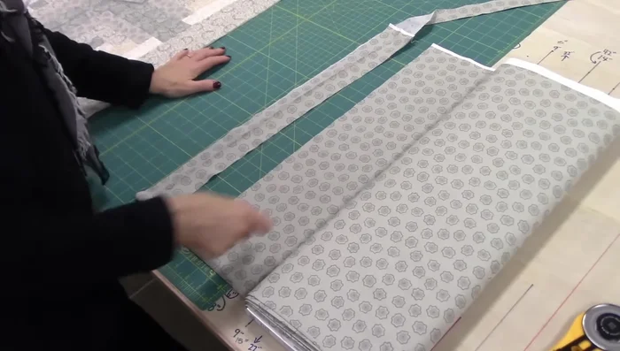 Iron the long binding strip in half, ensuring raw edges are even.