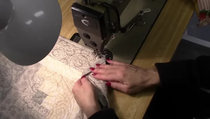 For corners, fold the binding at a 45° angle to the back. Secure with pins if needed and stitch. Repeat for each corner.