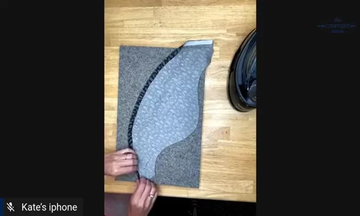 Turn the hem under again by another quarter inch, tucking it into the previous fold. Pin and press again.