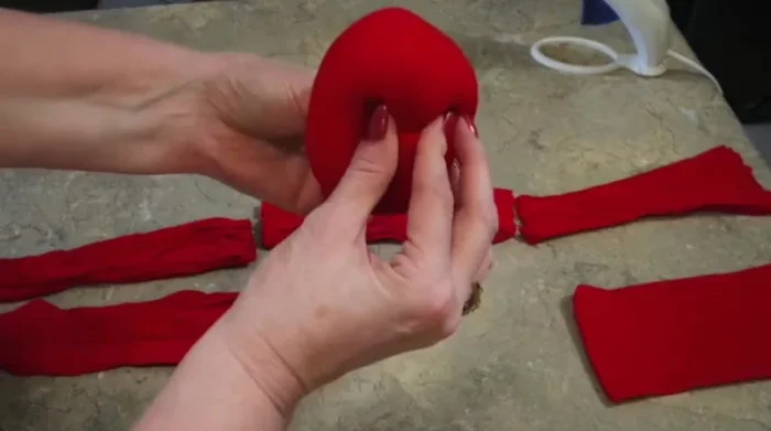 Shape and adjust the apple, squeezing and molding it into a desired shape.