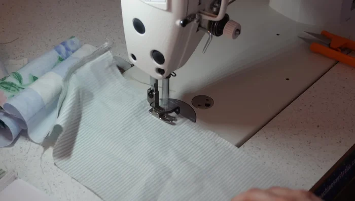 Gather the loop: Sew two parallel gathering stitches along the top edge of the loop. Pull threads to gather.