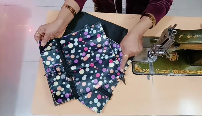 Sew the base piece to the main fabric pieces: Attach the 11x18 inch pieces, with the zippers attached, to the main fabric.