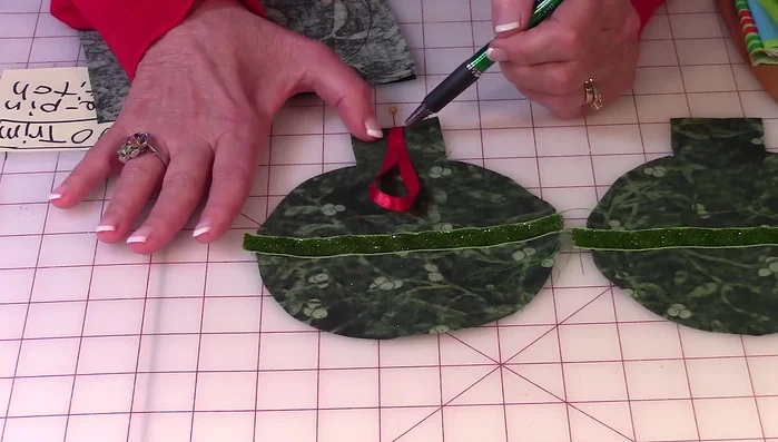 Pin the two fabric pieces right sides together, aligning the ribbons. Place pins strategically to ease removal during stitching.