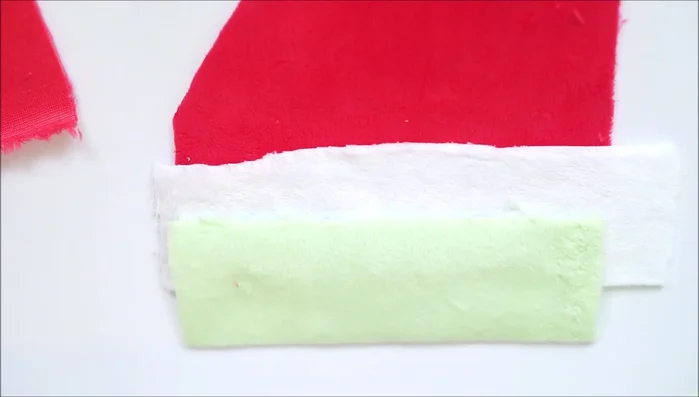 Sew white and green plush strips onto each red fabric piece, creating the watermelon stripes.