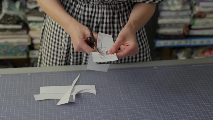 Prepare the fabric: Lay the fabric flat and place the pattern pieces on top, aligning them carefully with the grain line.