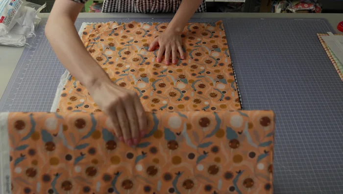 Prepare the fabric: Lay the fabric flat and place the pattern pieces on top, aligning them carefully with the grain line.