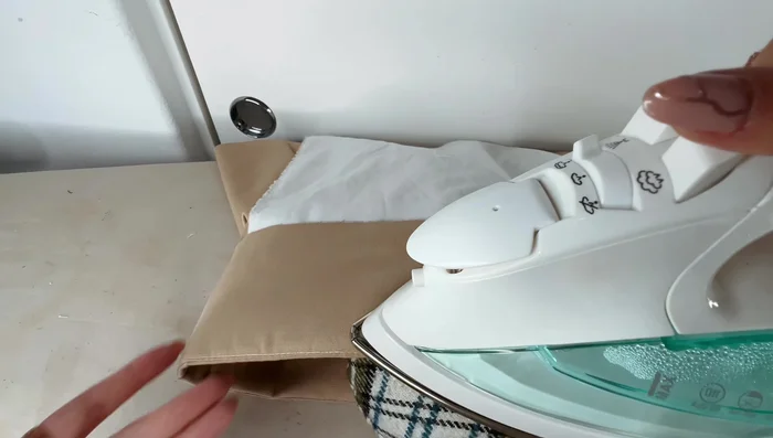 Iron down the top of the waistband, folding the lining yoke slightly over the waist seam. Pin in place. Sew in the ditch to secure.