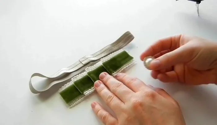 Attach the gem or pearl to the end of the velvet ribbon using hot glue.