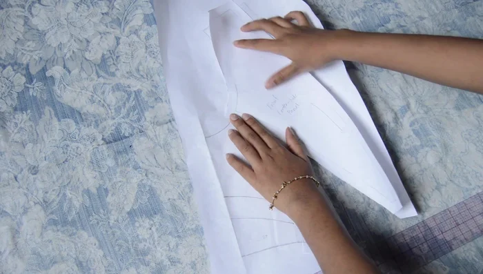 Create the Bodice: Trace a regular bodice pattern, add style lines, trace individual pieces with seam allowance on new paper. For pleated pieces, make horizontal lines on pattern, cut rectangles, insert paper between pieces for pleating.