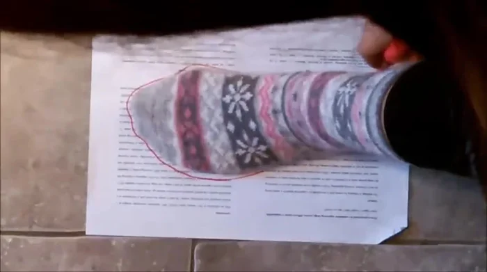 Create the slipper pattern. Fold the paper in half, and mark 4.5 inches from the middle line at the bottom. Connect this point with the top folded line, then create an inward curve 2 inches from the folded line for the slipper's inside.