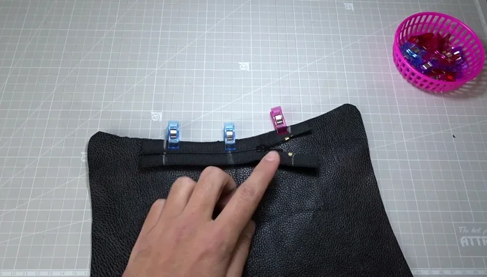 Sew the zipper to the first leather piece from the bottom stop to the top stop, using long stitches and a zipper foot. Remember to backstitch at the beginning and end. Lower the needle and raise the presser foot to open the zipper halfway for easier sewing.