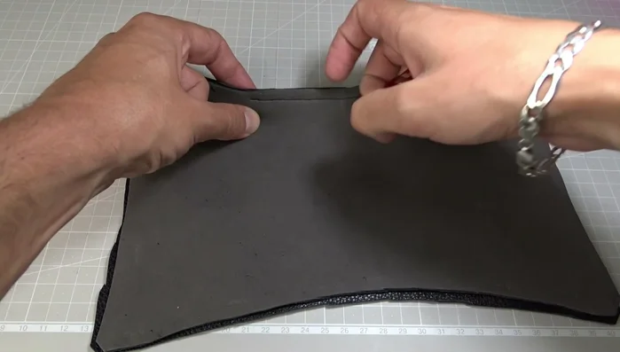 Open the zipper, align the edges of the leather, and clip the edges together. Mark the seam line and add more clips to secure all sides. Pull the zipper ends to the outside.