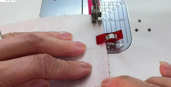 Stitch across the lining and outer fabric, close to the zipper teeth.