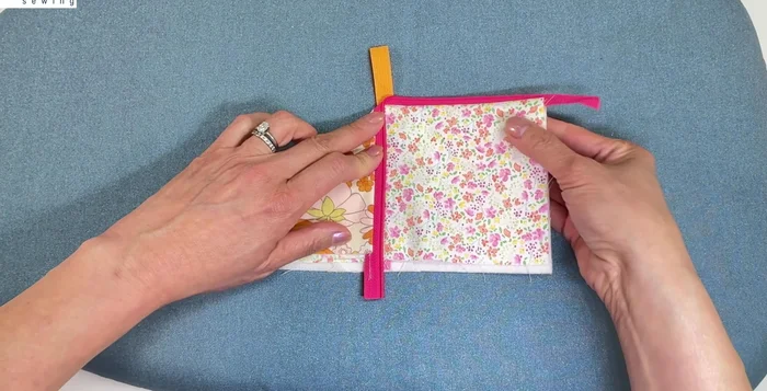 Fold down both sides of the zipper to the middle, trim the bottom, and install the slider.