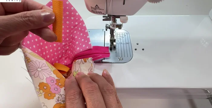 Attach the shorter loop of tape to the bottom of the zipper.