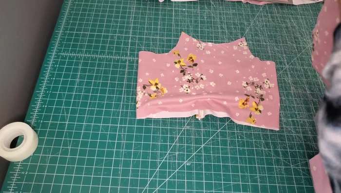 Attach Binding to Neckline: Place the main fabric piece and lining right sides together. Use the binding attachment to bind the neckline, ensuring the fabric is in the groove and the binding isn't twisting.