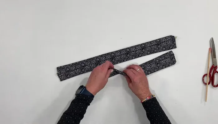 Place the two strips together, seam sides facing each other, and flatten.