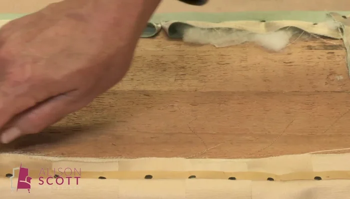 Line the inside of the lid using back tack card. Add a thin layer of wadding to soften the fabric away from the wooden edge. Secure with pins before ladder stitching.