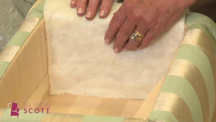 Line the underside of the lid, ensuring wadding doesn't extend beyond the frame. Trim excess fabric and wadding to the edge. Temporary tacks are used for ease of adjustment.