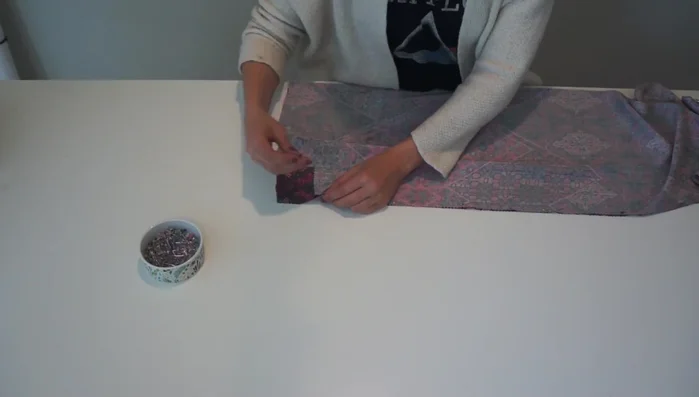 Prepare the fabric: Fold the reclaimed fabric in half, then in half again in the opposite direction. Pin and cut the front and back pieces simultaneously using a pre-existing cami top as a pattern.