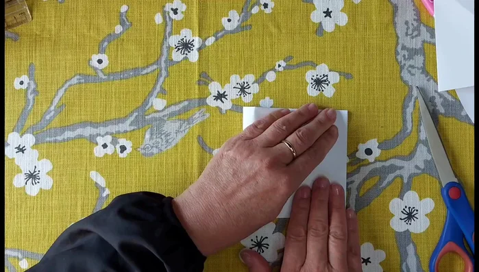 Fold the rectangle in half again to create a smaller square.