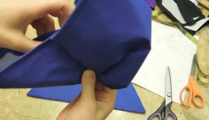 Attach the smaller, folded fabric piece to the center of the bow.