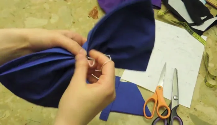 Attach the smaller, folded fabric piece to the center of the bow.