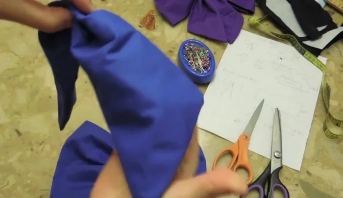 Attach the smaller, folded fabric piece to the center of the bow.