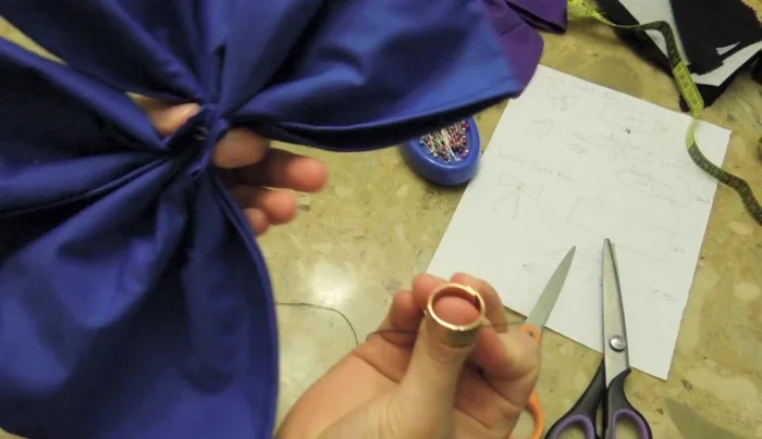 Hand-sew the small fabric piece to the back of the bow to secure it further. Leave some extra thread to attach safety pins. 