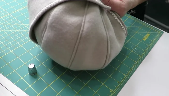 Hand-sew the button to the corner of the brim.