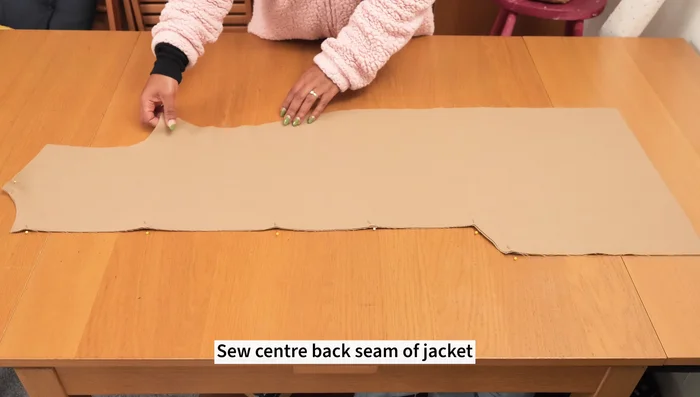 Stitch the storm shield pieces together and attach them to the back of the jacket, incorporating them into the side seams.