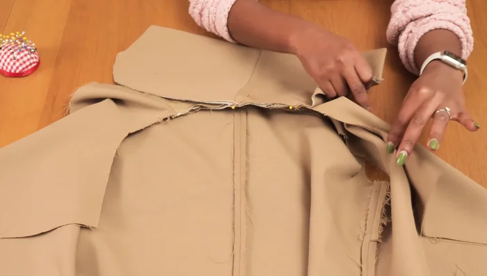 Pin and sew the collar to the jacket neckline, sandwiching it between the jacket and facing. Sew the center front edges, connecting lining to jacket.