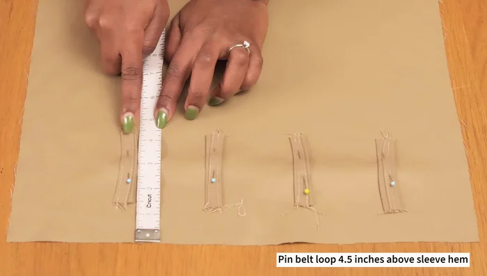 Attach the sleeves to the armholes, easing the fabric to ensure a smooth fit and positioning the epaulettes.