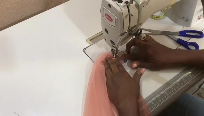 Gather the net: Raise the presser foot, ensure the fabric is full under the foot, then lower the foot and stitch gently to gather the net.