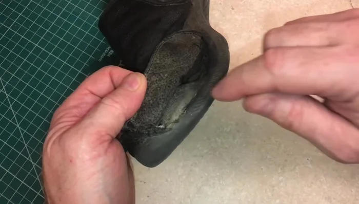 For tight areas, go sideways with the needle to ensure the stitch is secure. Stitch the leather tightly to the bottom of the shoe.