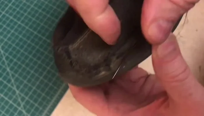 For tight areas, go sideways with the needle to ensure the stitch is secure. Stitch the leather tightly to the bottom of the shoe.