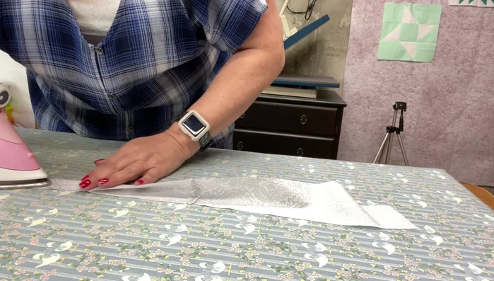 Fold the handle strip in half lengthwise and press. Fold it in half again, press, and stitch to secure.