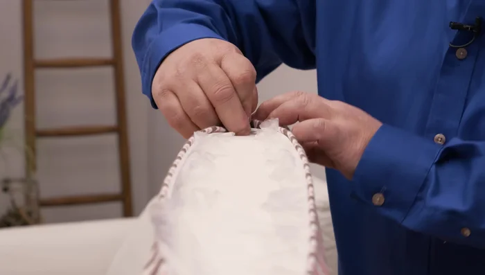 Zip up the cushion, ensuring the slider is not caught on any silk film or excess fabric.