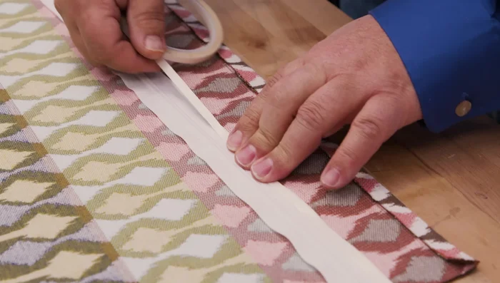 Apply the zipper, basting it in place using the double-sided tape and then sew it to the fabric.
