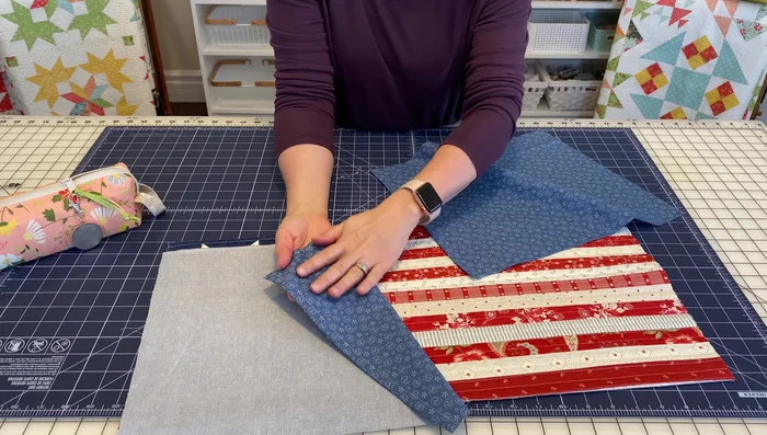 Place the pillow front right side up. Position the two backing pieces right sides together, aligning the hemmed edges with the pillow front edges and ensuring even overlaps. Secure with Clover Wonder Clips.