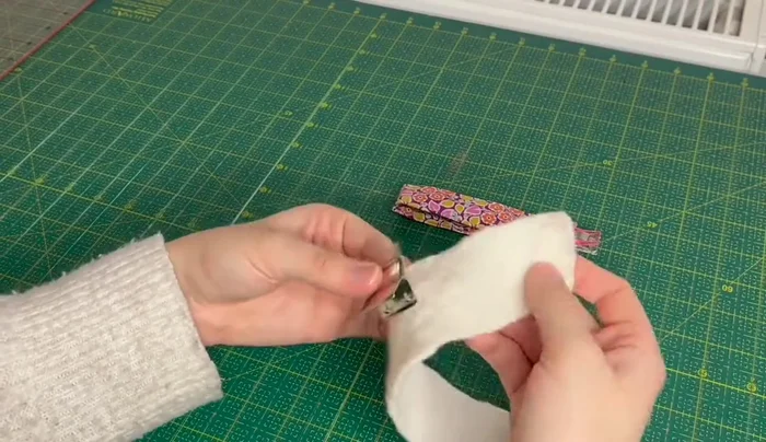 Partially close the metal key fob tab with pliers.