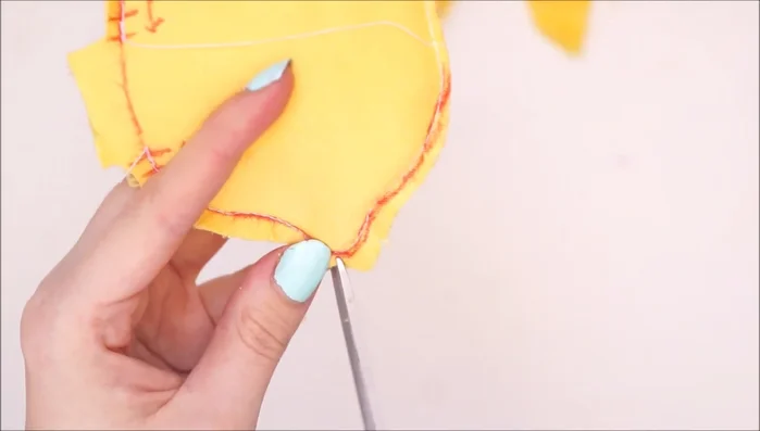 Trim excess fabric and make small snips around the curved edges to facilitate turning. Turn the lemon right-side out.