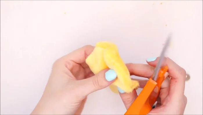 Press out any bumps and shape the lemon. Cut small holes and attach toy safety eyes with washers on the inside to secure them.