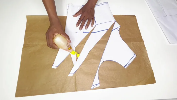 Transfer the front and back patterns onto the fabric, ensuring the stretch is across the width for the front and along the length for the back. Cut out the fabric pieces.