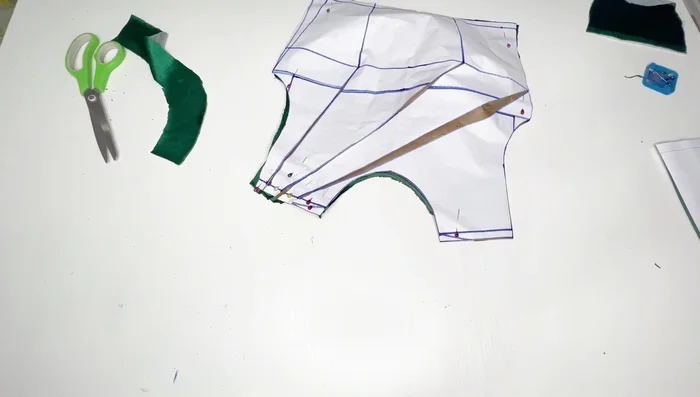 Stitch the front pleats at the shoulder line using your sewing machine (1/2 inch seam allowance). Attach the neckline facing.