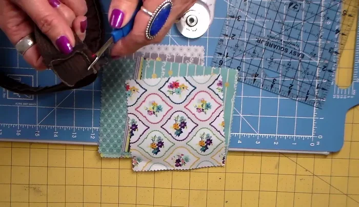 Remove the buckle from the thrift store belt using a seam ripper.