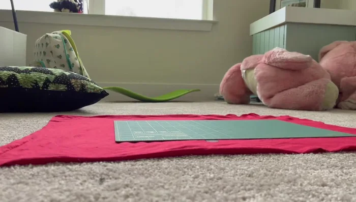 Cut a 6-7 inch strip from the bottom of the t-shirt to use as a sleeve for the pillowcase.